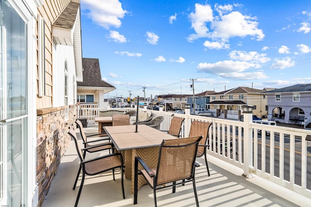 balcony with outdoor dining area and a residential view