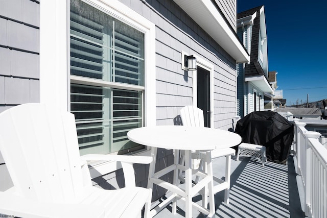 wooden terrace featuring a grill and outdoor dining area