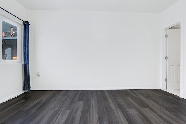 empty room with dark wood-style floors and baseboards