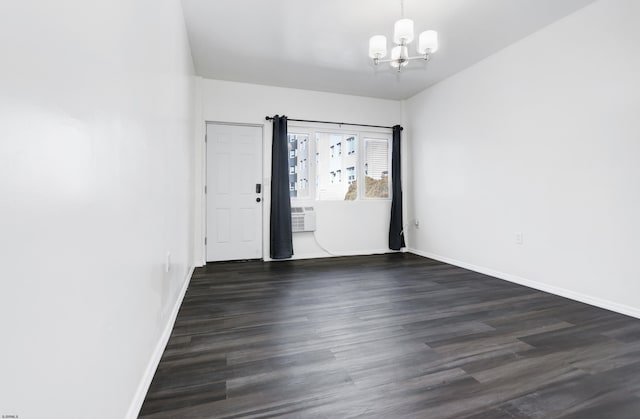 empty room with dark wood-style floors, baseboards, and an inviting chandelier