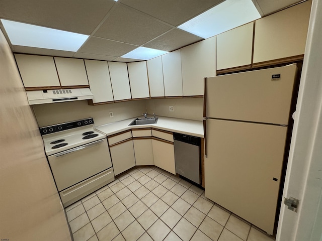 kitchen with a paneled ceiling, light countertops, a sink, ventilation hood, and white appliances