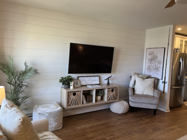 living area with a ceiling fan and wood finished floors