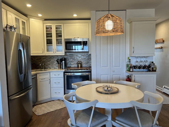 kitchen with decorative backsplash, dark wood-type flooring, decorative light fixtures, stainless steel appliances, and light countertops