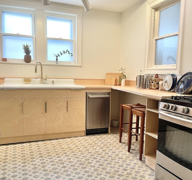 kitchen featuring light countertops, light floors, and stainless steel range with gas stovetop