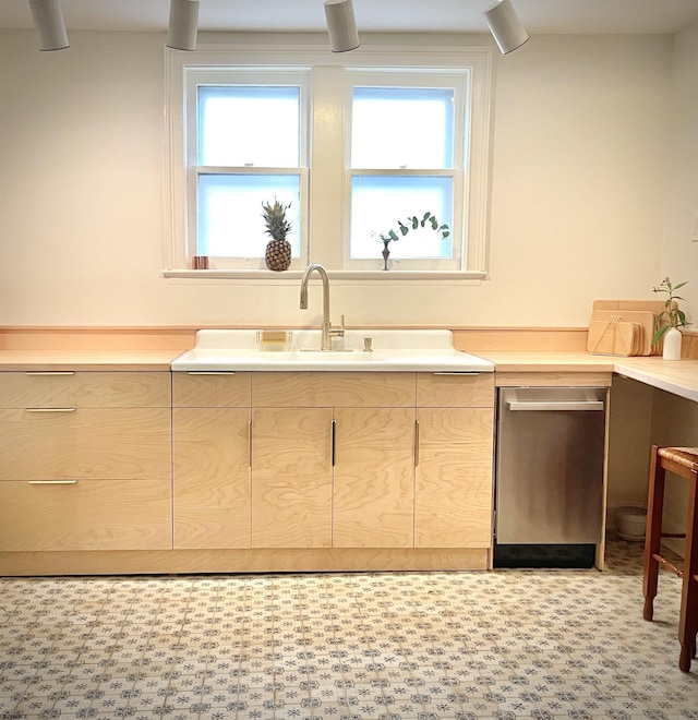 kitchen featuring tile patterned floors, light countertops, a sink, and light brown cabinetry