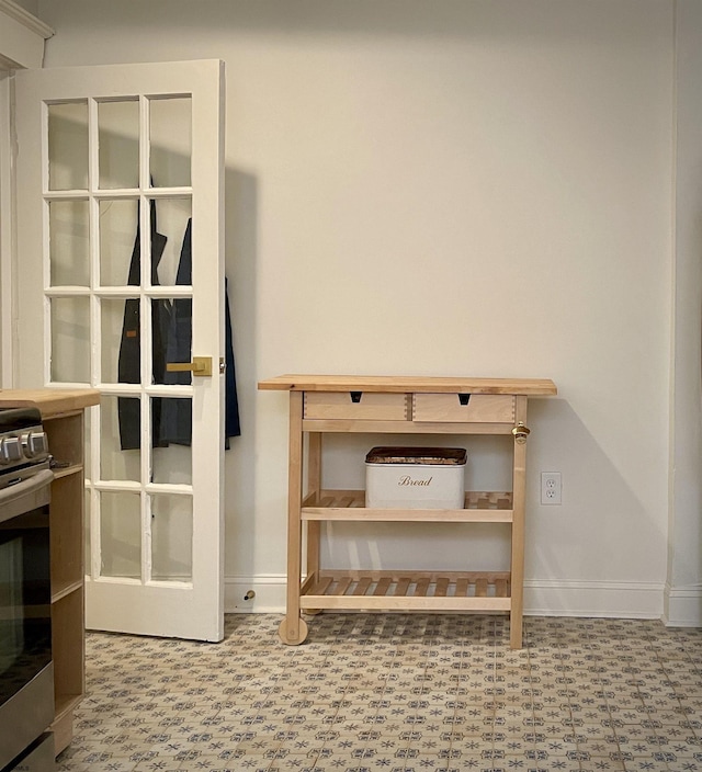 details featuring stainless steel electric range, baseboards, and tile patterned floors