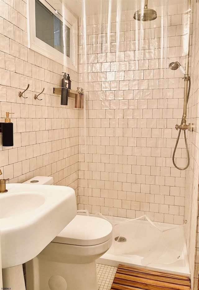 bathroom with tile walls, a shower stall, and toilet