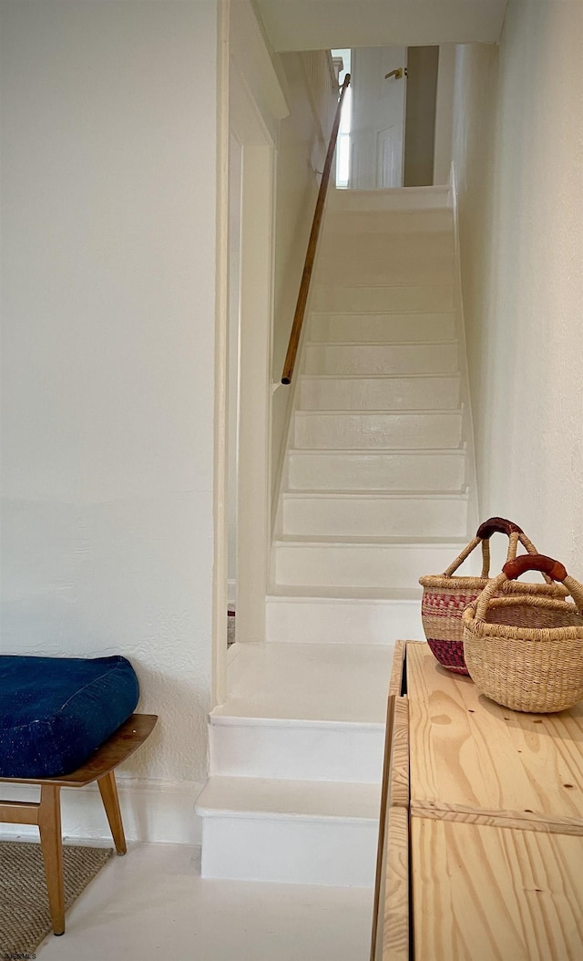 staircase featuring a textured wall