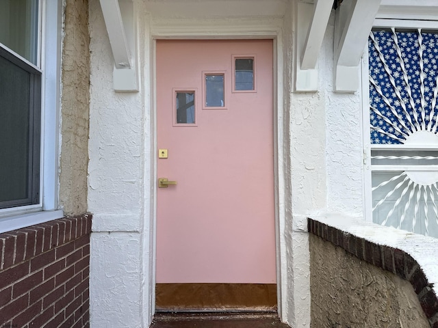 view of exterior entry with stucco siding