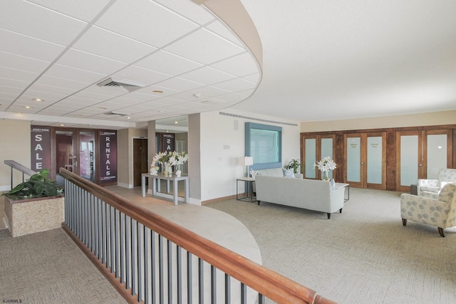 corridor featuring visible vents, baseboards, a drop ceiling, french doors, and carpet floors