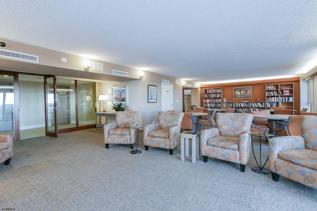 living room featuring carpet floors, french doors, visible vents, and a textured ceiling