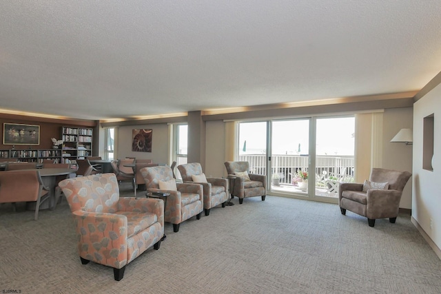 carpeted living room featuring a textured ceiling and baseboards