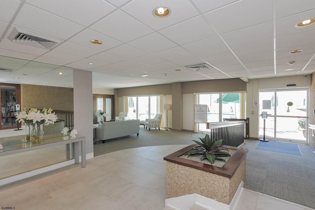 carpeted living area featuring recessed lighting, visible vents, and a drop ceiling