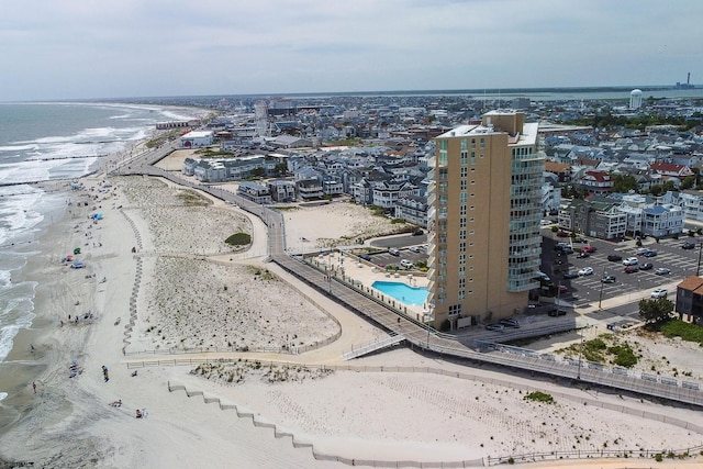 drone / aerial view with a water view, a view of city, and a view of the beach