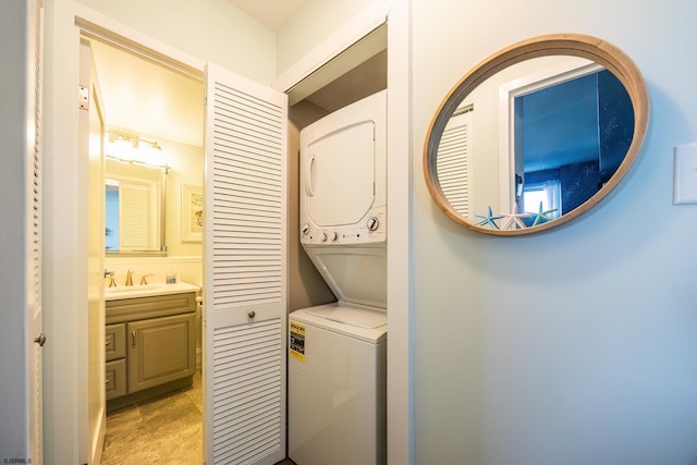 laundry area with stacked washer and dryer, laundry area, and a sink