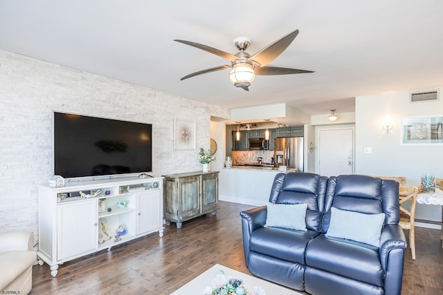 living area with ceiling fan, visible vents, and dark wood-type flooring