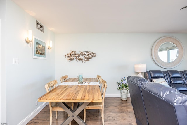 dining room featuring visible vents, baseboards, and wood finished floors