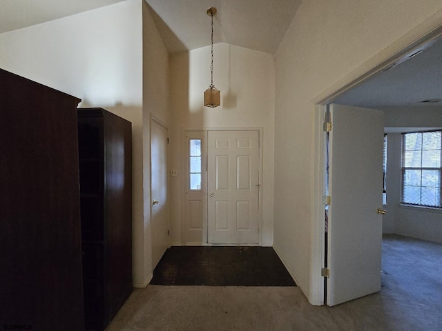 foyer entrance with high vaulted ceiling, carpet, and visible vents