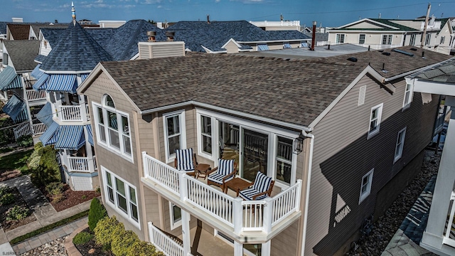 exterior space with a chimney and roof with shingles