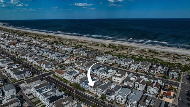 birds eye view of property featuring a beach view, a water view, and a residential view