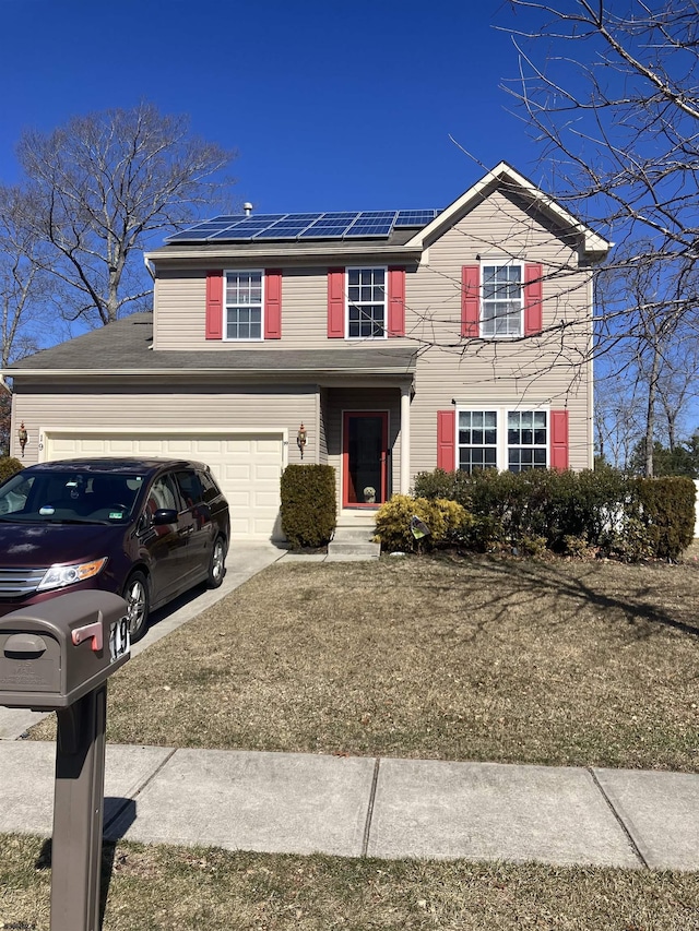 traditional home featuring a garage, solar panels, and driveway