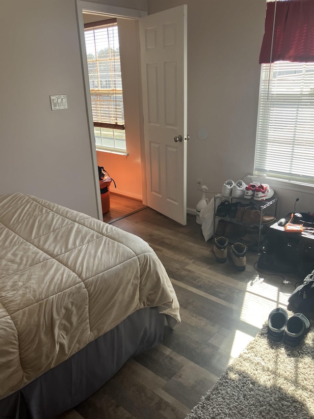 bedroom featuring wood finished floors and multiple windows