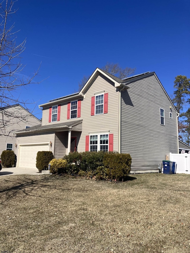 view of front facade with driveway, a front lawn, a garage, and fence