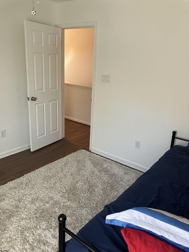 bedroom featuring baseboards and wood finished floors