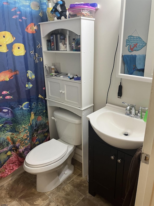 bathroom with toilet, vanity, and curtained shower