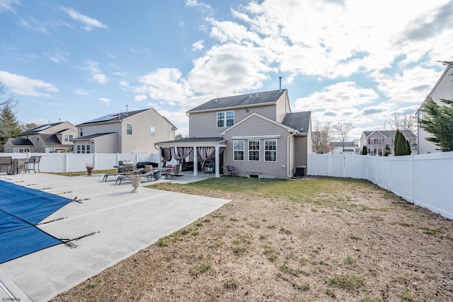 rear view of house featuring a patio area, cooling unit, a fenced backyard, a residential view, and a lawn