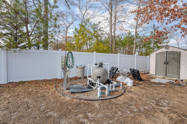 view of yard featuring an outbuilding, a storage unit, and a fenced backyard