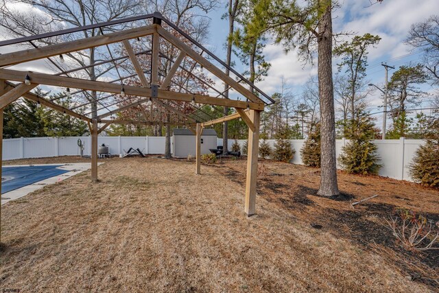 view of yard featuring an outbuilding, a fenced backyard, and a storage shed