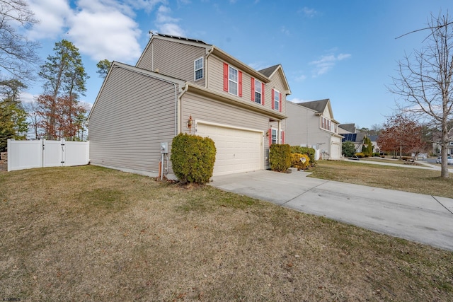 view of side of home featuring fence, an attached garage, driveway, a gate, and a lawn