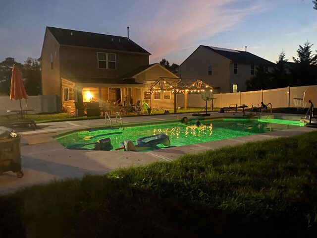 pool at dusk with a fenced in pool, fence private yard, and a patio area