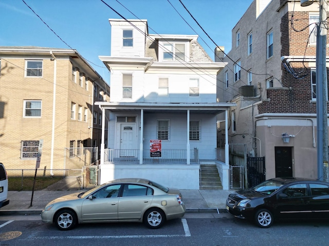 view of front of home with covered porch and fence