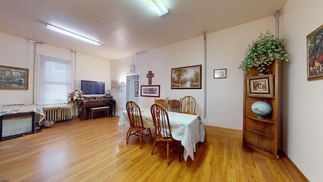 dining room with radiator and light wood-style flooring