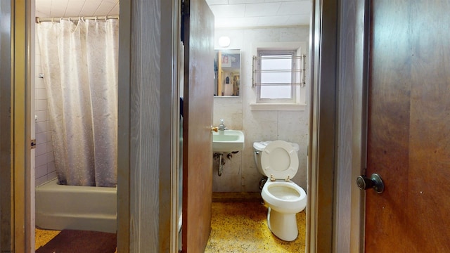 full bathroom featuring a sink, shower / bath combination with curtain, and toilet