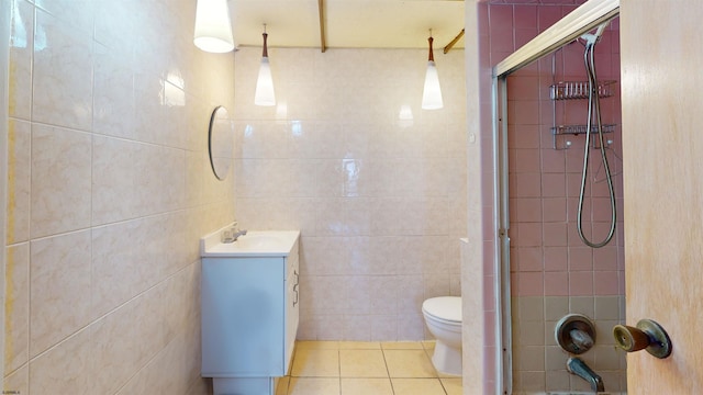 full bathroom with tile patterned flooring, toilet, vanity, tile walls, and a shower