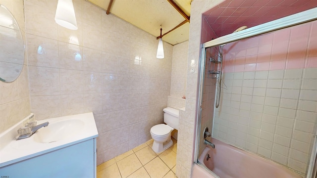 full bathroom featuring enclosed tub / shower combo, toilet, vanity, tile walls, and tile patterned floors