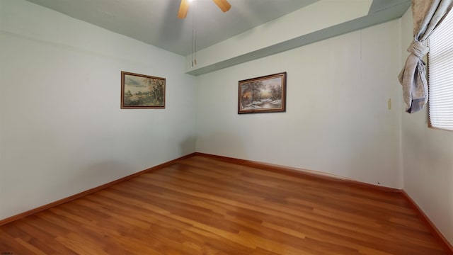 empty room with ceiling fan, baseboards, and wood finished floors