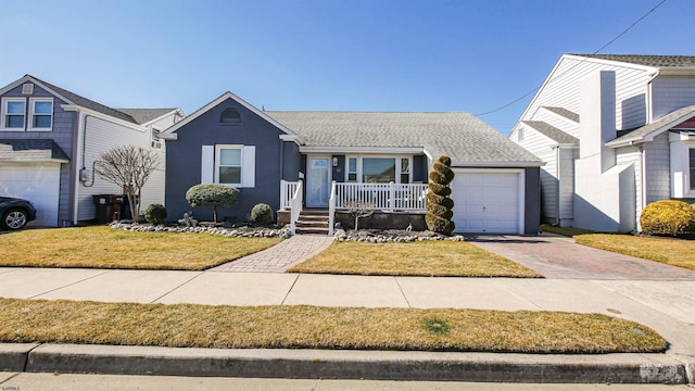 view of front of house with a porch, an attached garage, a shingled roof, driveway, and a front lawn