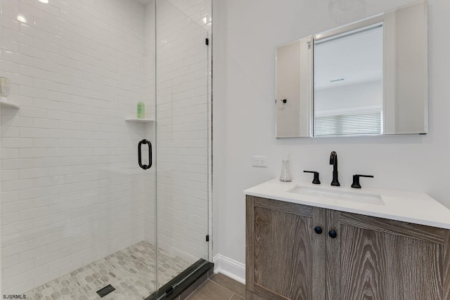 bathroom featuring a shower stall, baseboards, tile patterned flooring, and vanity