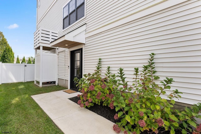 entrance to property featuring a yard and fence