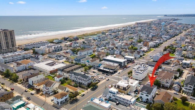 drone / aerial view with a water view and a beach view