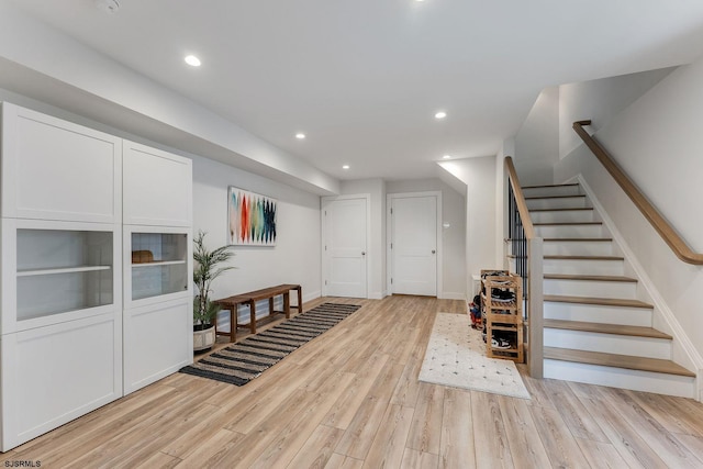 entryway featuring baseboards, stairway, light wood-type flooring, and recessed lighting