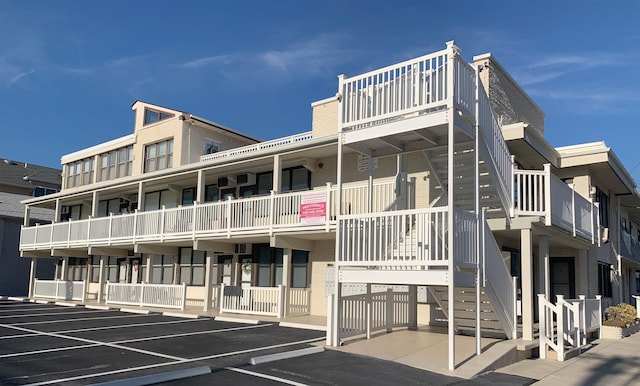 view of building exterior featuring uncovered parking and stairs