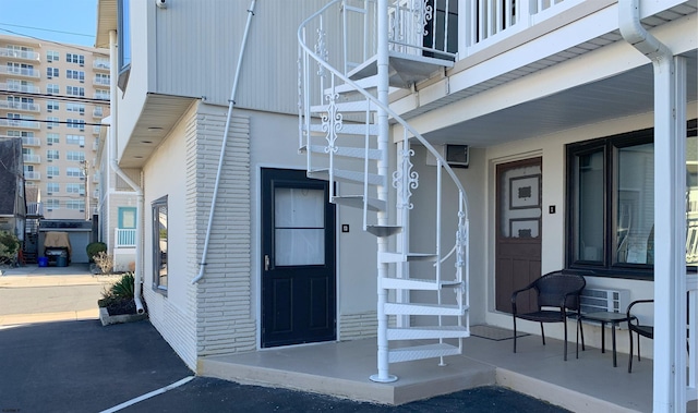 view of exterior entry featuring covered porch and brick siding