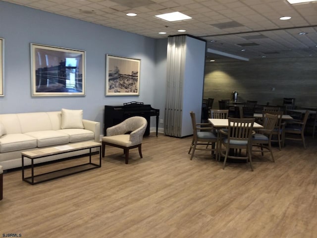 interior space with a paneled ceiling and wood finished floors