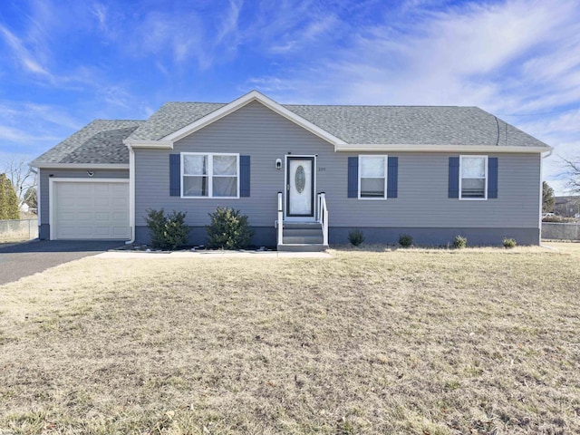 ranch-style home featuring a garage, fence, a front lawn, and roof with shingles