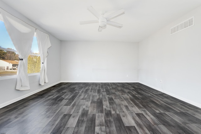 spare room featuring visible vents, dark wood finished floors, and baseboards